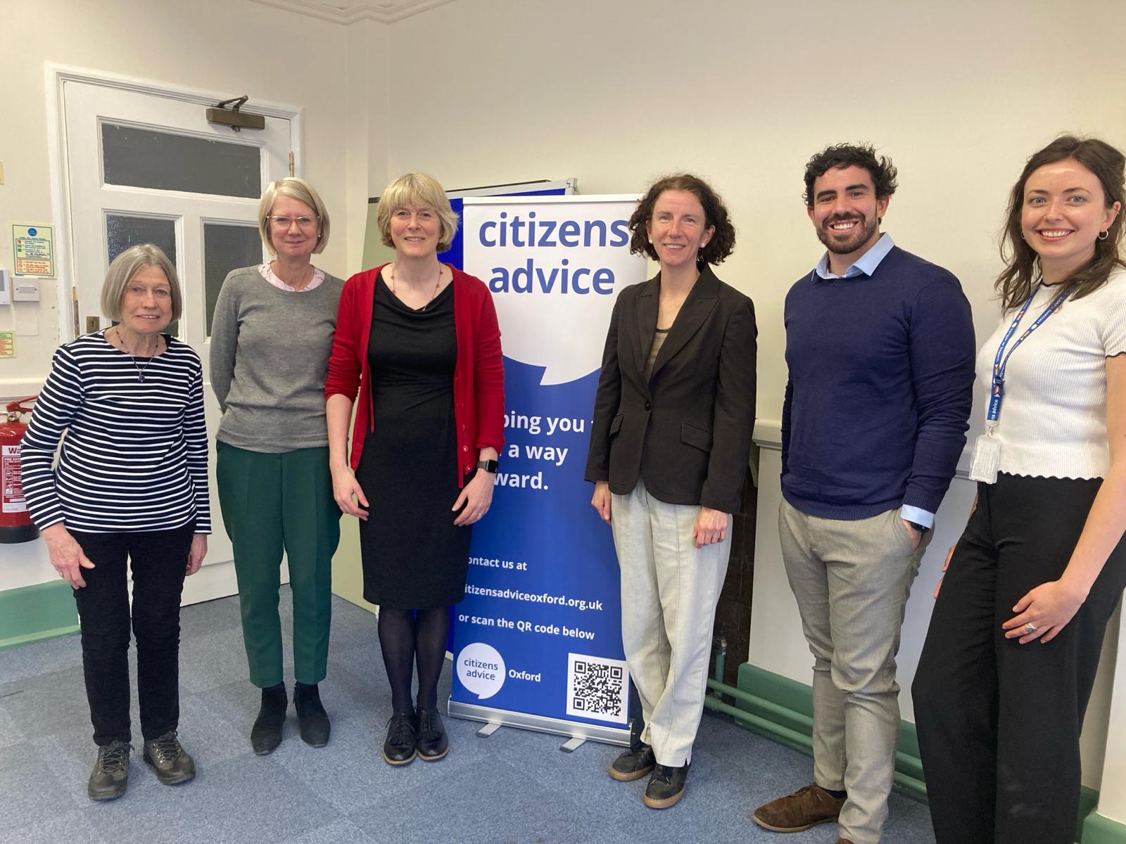 Photo of me with five staff from Citizens Advice, standing in front of a blue and white Citizens Advice roller banner